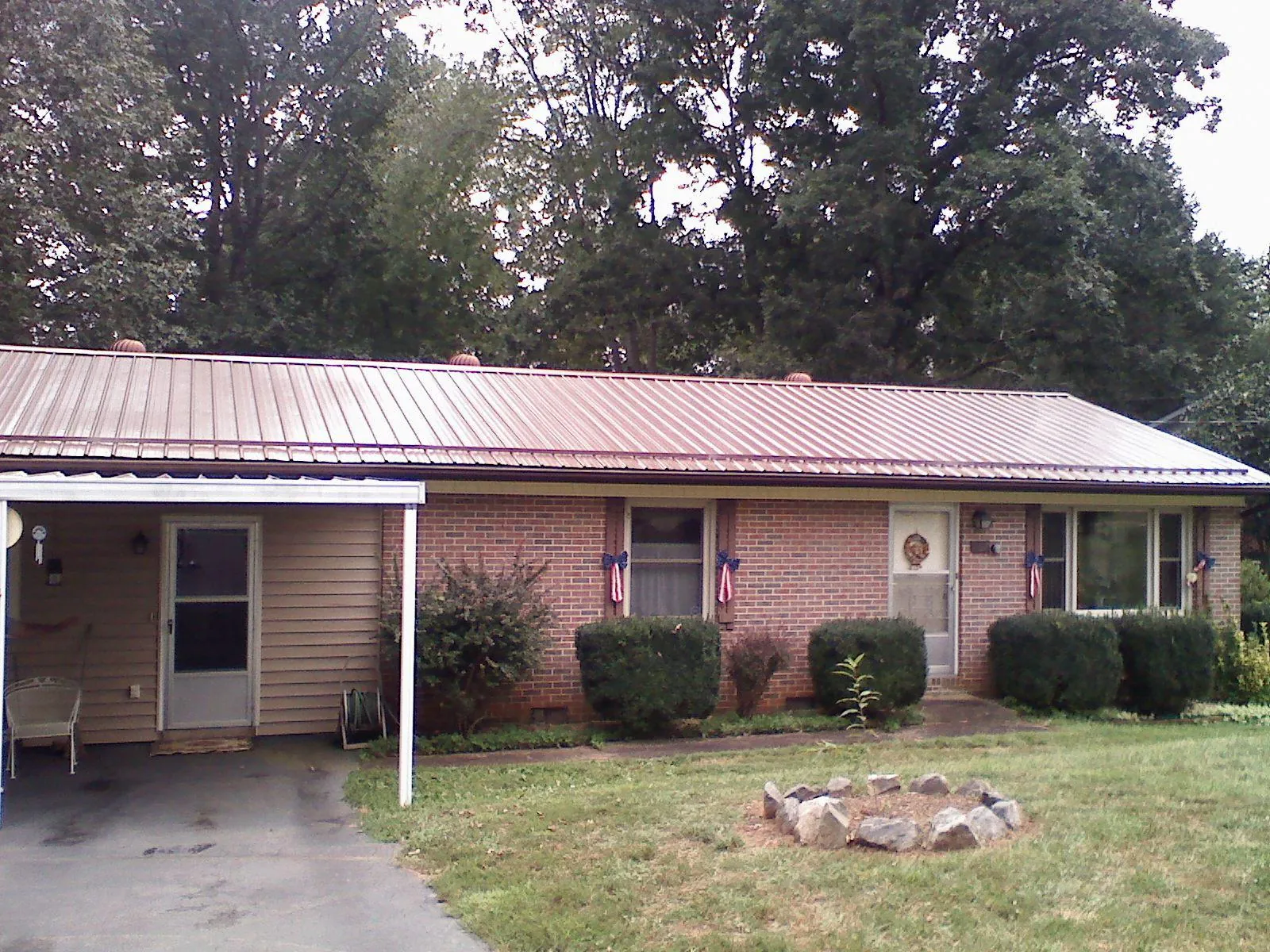Bronze metal roof and carport on a brick ranch home — Roof Repair work by our crew in Eaton